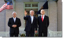 President George W. Bush waves to photographers as he stands with Palestinian President Mahmoud Abbas, left, and Prime Minister Ehud Olmert Tuesday, Nov. 27, 2007, at the Annapolis Conference in Annapolis, Maryland. White House photo by Chris Greenberg