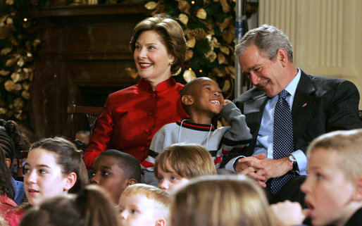 President George W. Bush and Mrs. Laura Bush share a moment with Malik Lawson during the Children's Holiday Performance Monday, Dec. 3, 2007, at the White House. The 7-year-old is the son of Sgt. Sherry Martin, currently serving in Iraq. White House photo by Joyce N. Boghosian