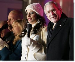 President George W. Bush joins Sara Evans in singing "We Wish you a Merry Christmas" on stage at the Ellipse Thursday, Dec. 6, 2007, during the festivities surround the lighting of the National Christmas Tree. White House photo by Shealah Craighead