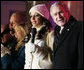 President George W. Bush joins Sara Evans in singing "We Wish you a Merry Christmas" on stage at the Ellipse Thursday, Dec. 6, 2007, during the festivities surround the lighting of the National Christmas Tree. White House photo by Shealah Craighead