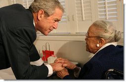 President George W. Bush speaks to a resident at the Little Sisters of the Poor of Washington, D.C., Tuesday, Dec. 18, 2007, during a visit with Mrs. Laura Bush to the facility that provides nursing and assisted-living services to elderly people of lesser means. White House photo by Shealah Craighead