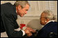 President George W. Bush speaks to a resident at the Little Sisters of the Poor of Washington, D.C., Tuesday, Dec. 18, 2007, during a visit with Mrs. Laura Bush to the facility that provides nursing and assisted-living services to elderly people of lesser means. White House photo by Shealah Craighead