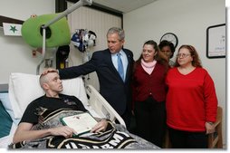 President George W. Bush visits with U.S. Army Sgt. John Wayne Cornell of Lansing, Mich., after presenting him with a Purple Heart Thursday, Dec. 20, 2007, during a visit to Walter Reed Army Medical Center in Washington, D.C., where he is recovering from injuries suffered in Operation Iraqi Freedom. With them are Sgt. Cornell's wife, Dee, and mother-in-law Diane Elaine Galloway. White House photo by Joyce N. Boghosian