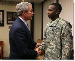 President George W. Bush shakes the hand of U.S. Army PFC Demario Hicks of Fort Stewart, Ga., Thursday, Dec. 20, 2007, after presenting him with a Purple Heart during his visit to Walter Reed Army Medical Center in Washington, D.C., where the soldier is recovering from injuries suffered in Operation Iraqi Freedom. White House photo by Joyce N. Boghosian