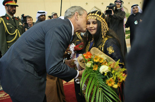 President George W. Bush gives a kiss on the cheek to a young girl Friday, Jan. 11, 2008, after she presented him with flowers upon his arrival at Kuwait International Airport in Kuwait City. White House photo by Eric Draper