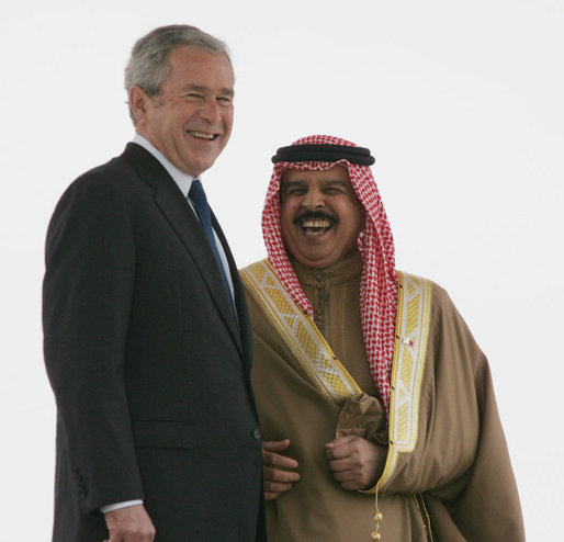 President George W. Bush smiles as he stands with King Hamad Bin Isa Al-Khalifa as they view the honor guard Saturday, Jan. 12, 2008, during arrival ceremonies in Manama, Bahrain. White House photo by Chris Greenberg