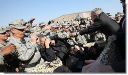 Troops reach out for President George W. Bush as he leaves the stage after delivering remarks to military personnel and coalition forces at Camp Arifjan before departing Kuwait Saturday, Jan. 12, 2008, for Bahrain. White House photo by Eric Draper