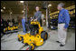 As Bill Wright, Founder and Chief Executive Officer of Wright Manufacturing, Inc., looks on, President George W. Bush stands on a "Stander" lawn mower in its final testing stage Friday, Jan. 18, 2008, during his visit to the Frederick, Maryland facility. Said the President during the visit, "Let me tell you why I'm here. This man started his own business. He's a manufacturer, he employs over a hundred people, and he represents the backbone of the American economy. And today I talked about our economy, and the fundamentals are strong, but there's uncertainty. And there's an opportunity to work with Congress to pass a pro-growth package that will deal with the uncertainty." White House photo by Joyce N. Boghosian