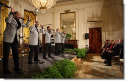 President George W. Bush joins the Temptations on stage in the East Room of the White House Tuesday, Feb. 12, 2008, after they performed during the celebration of African American History Month. White House photo by Eric Draper