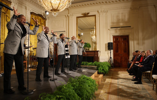 President George W. Bush joins the Temptations on stage in the East Room of the White House Tuesday, Feb. 12, 2008, after they performed during the celebration of African American History Month. White House photo by Eric Draper