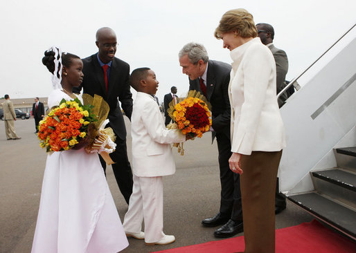 President George W. Bush and Mrs. Laura Bush are greeted by children with flowers on their arrival Tuesday, Feb. 19, 2008 to Kigali International Airport in Kigali, Rwanda. White House photo by Eric Draper