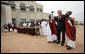 President George W. Bush greets cultural dancers during his visit Tuesday, Feb. 19, 2008, to the dedication and official opening of the new U.S. Embassy in Kigali, Rwanda. White House photo by Eric Draper