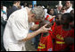 President George W. Bush embraces a young boy after a tee ball game Wednesday, Feb. 20, 2008, at the Ghana International School in Accra, Ghana. White House photo by Eric Draper