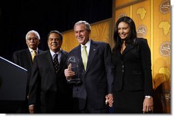 President George W. Bush is presented with an award by Ambassador Andy Young, Chairman of the Board, The Leon H. Sullivan Foundation, for his dedication and committed service to Africa, after speaking to The Leon H. Sullivan Foundation Tuesday, Feb. 26, 2008, in Washington, D.C. Joining them on stage is Ambassador Howard Jeter, president and CEO of The Leon H. Sullivan Foundation, far left, and Hope Masters, daughter of the late Rev. Leon H. Sullivan. White House photo by Eric Draper