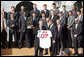 President George W. Bush is presented with a personalized Boston Red Sox jersey from team captain Jason Varitek, as President Bush honored the 2007 World Series Champions Wednesday, Feb. 27, 2008, on the South Lawn of the White House. White House photo by Joyce N. Boghosian