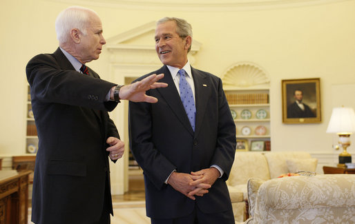 President George W. Bush smiles as he listens to Senator John McCain Wednesday, March 5, 2008, in the Oval Office as they prepared to meet the media on the South Lawn. The President offered his endorsement of the Republican presidential candidate saying, "John showed incredible courage and strength of character and perseverance in order to get to this moment. And that's exactly what we need in a President: somebody that can handle the tough decisions; somebody who won't flinch in the face of danger." White House photo by Eric Draper