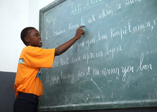 A student at the IDEJEN educational program reads from a chalkboard Thursday March, 13, 2008, during Mrs. Laura Bush's visit to the program at the College de St. Martin Tours in Port-au-Prince, Haiti. White House photo by Shealah Craighead