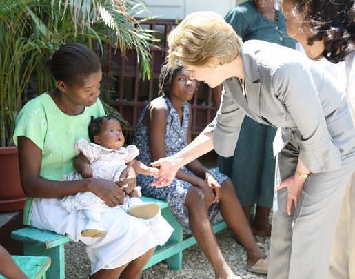 Mrs. Laura Bush is introduced to a participant and her infant daughter at the GHESKIO HIV/AIDS Center’s women’s clinic, Thursday, March 13, 2008, in Port-au-Prince, Haiti. The program was initiated to help improve the lives of HIV patients. White House photo by Shealah Craighead