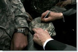 Vice President Dick Cheney autographs a hat during a rally for the troops Tuesday, March 18, 2008, at Balad Air Base, Iraq. White House photo by David Bohrer