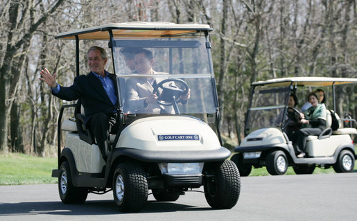 President George W. Bush waves as South Korean President Lee Myung-bak drives their golf cart, followed by Laura Bush and South Korea first lady Kim Yoon-ok in theirs Friday, April 18, 2008, at the Presidential retreat at Camp David, Md. White House photo by Shealah Craighead