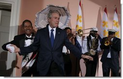 President George W. Bush steps on stage at the U.S. Chamber of Commerce reception to join members of the Euphonic Jazz Band Monday evening, April 21, 2008, prior to attending the 2008 North American Leaders’ Summit dinner in New Orleans. White House photo by Joyce N. Boghosian