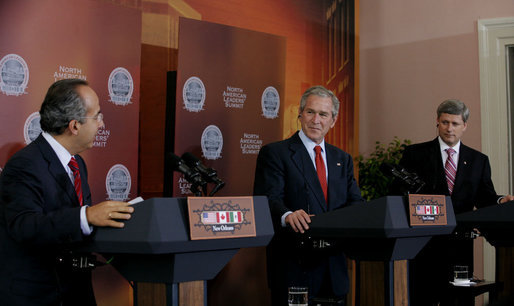 President George W. Bush and Canadian Prime Minister Stephen Harper listen to Mexico President Felipe Calderon as he responds to a reporter’s question, during their joint news conference Tuesday, April 22, 2008 in New Orleans, at the conclusion of the 2008 North American Leaders’ Summit. White House photo by Joyce N. Boghosian