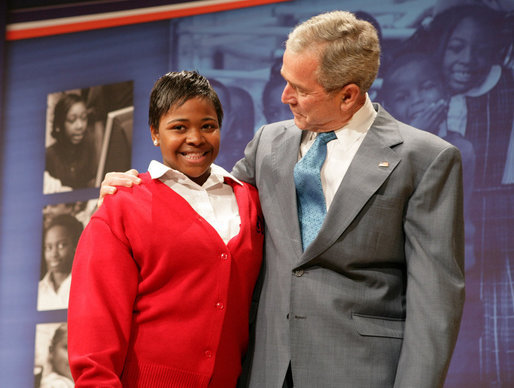 President George W. Bush stands with his arm around Aysia Mayo-Gray, a student at St. Ann's Academy in Washington, D.C., and one of the greeters on hand to welcome the President to the White House Summit on Inner-City Children and Faith-Based Schools Thursday, April 24, 2008, at the Ronald Reagan Building and International Trade Center. Said the President after being introduced by the 14-year-old, "Aysia, thanks for the introduction -- you did a fabulous job. I'm told that your's a very hard worker who loves school, and it's clear you always wear a smile." White House photo by Chris Greenberg