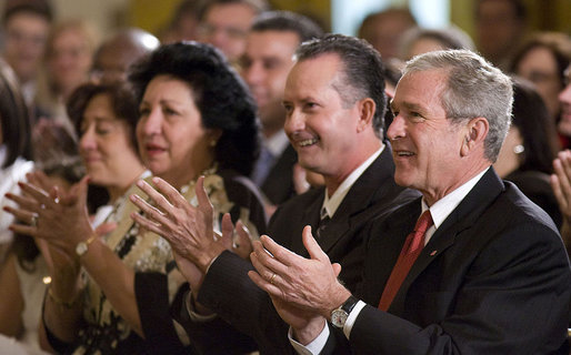 President George W. Bush applauds the entertainment of vocalist Willy Chirino during a Day of Solidarity with the Cuban People Wednesday, May 21, 2008, in the East Room of the White House. Seated next to him are Miguel Sigler Amaya, a former political prisoner, and his wife, Josefa Lopez Pena. White House photo by Joyce N. Boghosian