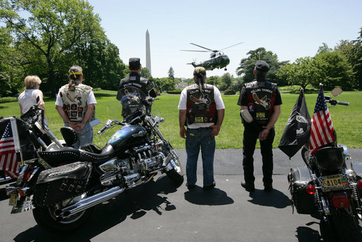 Members of the motorcycle group Rolling Thunder watch President George W. Bush and First Lady Laura Bush land on the South Lawn of the White House from a visit to Camp David. White House photo by Chris Greenberg