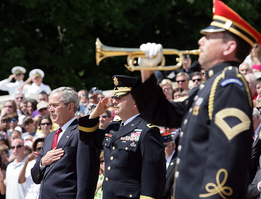 President George W. Bush is accompanied by Major General Richard J. Rowe Jr., commander of the Military District of Washington, right, as he holds his hand over his heart during the playing of taps at the Tomb of the Unknowns during a Memorial Day ceremony Monday, May 26, 2008 at Arlington National Cemetery in Arlington, VA. White House photo by Chris Greenberg