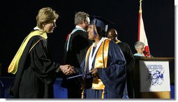 Mrs. Laura Bush congratulates a graduate during commencement exercises Thursday, May 29, 2008, at Enterprise High School in Enterprise, Alabama. Mrs. Bush was on hand to deliver the commencement address, and she told the class -- that lost four of its members in deadly tornadoes last year -- and told the Class of 2008, "As you graduate tonight, take with you memories of your teachers' and classmates' support after the storm, the blue and white worn by students at rival schools, and the donations that came pouring in from around the country." White House photo by Shealah Craighead