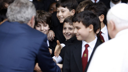 President George W. Bush shakes hands with members of The Pontifical Sistine Choir following their performance Friday, June 13, 2008, in the Lourdes Grotto at the Vatican. White House photo by Eric Draper