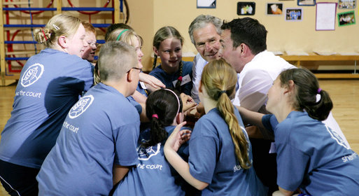 President George W. Bush participates in a basketball game huddle with members of the Peace Players basketball team and their coach Monday. June 16, 2008, during a visit to the Lough Integrated Primary School in Belfast, Ireland. White House photo by Chris Greenberg