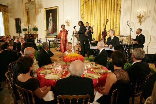 President George W. Bush joins invited guests Thursday evening, June 19, 2008 to the East Room of the White House, listening to vocalist Esther Williams and saxophonist Davey Yarborough during a social dinner in honor of American jazz. White House photo by Chris Greenberg