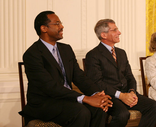 Dr. Benjamin Carson, left, seated with Dr. Anthony S. Fauci, listens Thursday, June 19, 2008, as he is announced as a recipient of the 2008 Presidential Medal of Freedom, at ceremonies in the East Room of the White House. White House photo by Shealah Craighead