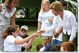 Mrs. Laura Bush takes a closer looks at a flower during a First Bloom planting event at Charlestown Navy Yard Sunday, June 22, 2008 in Boston, MA. Students of the Boys and Girls Club of Boston and Warren Prescott Elementary School participated in a three-day workshop that focused on invasive species, native plants, seed cultivation, garden design, and monitoring species. White House photo by Shealah Craighead