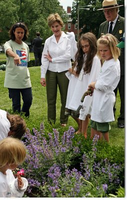 Mrs. Bush observes students of the Boys and Girls Club of Boston and Warren Prescott Elementary School who are planting gardens in the Charlestown Navy Yard Sunday, June 22, 2008 in Boston, MA, during a First Bloom event aimed at introducing children to plant species native to their area and educating kids about seed cultivation, garden design, and monitoring species. White House photo by Shealah Craighead