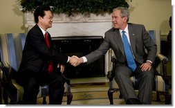 President George W. Bush exchanges handshakes with Prime Minister Nguyen Tan Dzung of the Socialist Republic of Vietnam, during their meeting Tuesday, June 24, 2008, in the Oval Office of the White House. White House photo by Eric Draper