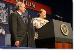 President George W. Bush listens as Edith Espinoza, Administrative Assistant, Chicano Federation, introduces him at the Office of Faith-Based and Community Initiatives National Conference Thursday, June 26, 2008, in Washington, D.C. The President opens his remarks, "How beautiful was that? From being a homeless mother of two to introducing the President of the United States. There has to be a higher power. I love being with members of the armies of compassion, foot soldiers in helping make America a more hopeful place. Every day you mend broken hearts with love. You mend broken lives with hope. And you mend broke communities with countless acts of extraordinary kindness."  White House photo by Chris Greenberg