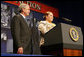 President George W. Bush listens as Edith Espinoza, Administrative Assistant, Chicano Federation, introduces him at the Office of Faith-Based and Community Initiatives National Conference Thursday, June 26, 2008, in Washington, D.C. The President opens his remarks, "How beautiful was that? From being a homeless mother of two to introducing the President of the United States. There has to be a higher power. I love being with members of the armies of compassion, foot soldiers in helping make America a more hopeful place. Every day you mend broken hearts with love. You mend broken lives with hope. And you mend broken communities with countless acts of extraordinary kindness." White House photo by Chris Greenberg