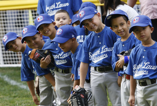 Players of the Jose M. Rodriguez Little League Angels of Manati, Puerto Rico, all look over toward President George W. Bush as he welcomes everyone to the 2008 Tee Ball on the South Lawn Season Opener Monday, June 30, 2008, on the South Lawn of the White House. White House photo by Eric Draper