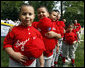 Players of the Cramer Hill Little League Red Sox of Camden, New Jersey hold their hats over their hearts during the singing of the National Anthem at the 2008 Tee Ball on the South Lawn Season Opener Monday, June 30, 2008, on the South Lawn of the White House. White House photo by Eric Draper