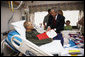 President George W. Bush awards a Purple Heart and citation to U.S. Marine Corps Sgt. Justin Clenard of Tehachapi, Calif., Thursday, July 3, 2008, at the National Naval Medical Center in Bethesda, Md. Looking on is Sgt. Clenard's father, Christopher Clenard, his stepmother, Kerrin Clenard, and his brother, Kevin Clenard. At far right is his mother, Lori Sander. White House photo by Eric Draper