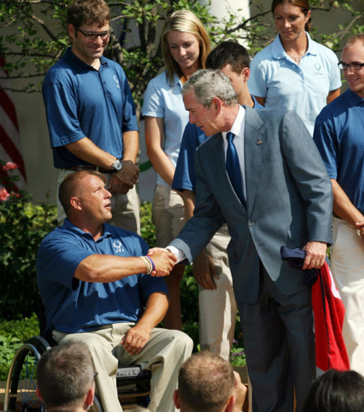 President George W. Bush shakes hands with Scott Winkler, 2008 U.S. Paralympics Track and Field team member, during a photo opportunity with the 2008 United States Summer Olympic Team Monday, July 21, 2008, in the Rose Garden of the White House. White House photo by Shealah Craighead