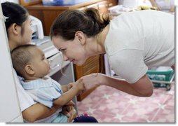 Ms. Barbara Bush, daughter of President George W. Bush and Mrs. Laura Bush, spends a playful moment with a small child during her visit to the Mae Tao Clinic at the Mae La Refugee Camp in Mae Sot, Thailand Thursday, Aug. 7, 2008.  White House photo by Shealah Craighead