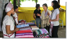 Mrs. Laura Bush and daughter Ms. Barbara Bush look over the weaving done by refugee women at the Mae La Refugee Camp at Mae Sot, Thailand, on Aug. 7, 2008. This traditional Karen craft helps the refugees make money and can be bought via the Internet through consortiums that work with the women in the camp which houses at least 39,000 Burmese. White House photo by Shealah Craighead