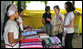 Mrs. Laura Bush and daughter Ms. Barbara Bush look over the weaving done by refugee women at the Mae La Refugee Camp at Mae Sot, Thailand, on Aug. 7, 2008. This traditional Karen craft helps the refugees make money and can be bought via the Internet through consortiums that work with the women in the camp which houses at least 39,000 Burmese. White House photo by Shealah Craighead