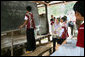 Mrs. Laura Bush watches as a student works at the chalkboard during a grammar class Thursday, Aug. 7, 2008, at the Mae La Refugee Camp in Mae Sot, Thailand. The exercise uses the sentence, "My life in refugee is better than Burma but I don't have opportunity to go outside of my camp" to discuss compound sentence structure. The visit to the camp highlighted the fact that it has been 20 years since the crackdown in Burma that sent many people fleeing dire conditions. Many residents have been born in one of the nine camps along the border or have lived most of their lives there. White House photo by Shealah Craighead