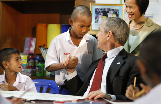 President George W. Bush connects with children at the Human Development Foundation - Mercy Centre in Bangkok on August 7, 2008. The non-profit group helps residents of the slums of Bangkok by building and operating schools and working on family health and welfare issues, such as AIDS and street children's rights. After visiting the school, President Bush participated in a briefing on disaster relief efforts in Burma at the Ambassador's residence and then met with Burmese activists and media before heading to China. White House photo by Eric Draper