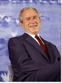 President George W. Bush smiles during an introduction by his father, former President George H.W. Bush Friday, Aug. 8, 2008, during the dedication of the United States Embassy in Beijing. White House photo by Eric Draper